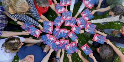 Mit vereinten Händen präsentieren Mitglieder der Operettenbühne Hombrechtikon die Flyeraktion zur diesjährigen Produktion. 