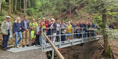 Die Gäste feiern die Einweihung der neuen Bruggtobelbachbrücke am Witzwanderweg in Wolfhalden.