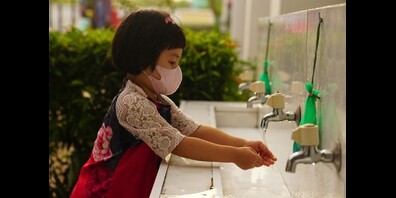 Händewaschendes Kind mit Maske. 