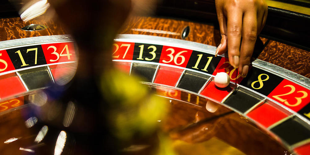 ARCHIV - Eine Mitarbeiterin der Spielbank Stuttgart greift beim Spiel Roulette nach einer Kugel, die auf Rot liegt. Foto: Christoph Schmidt/dpa
