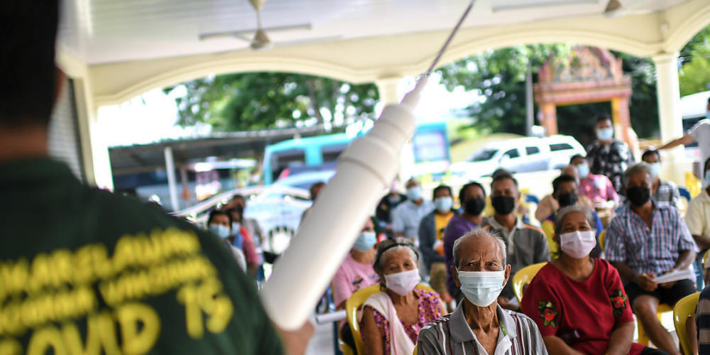 Eine Corona-Informationsveranstaltung im Bezirk Padang Terap in Malaysia über den Schutz vor dem Coronavirus und über die Impfung. Foto: Adib Hasri/BERNAMA/dpa