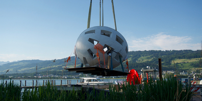 Das Globo uovo schwebt per Kran auf die Insel Ufnau.