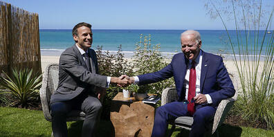 Joe Biden (r), Präsident der USA, und Emmanuel Macron, Präsident von Frankreich, schütteln sich die Hand bei einem gemeinsamen Treffen während des G7-Gipfels. Foto: Patrick Semansky/AP/dpa
