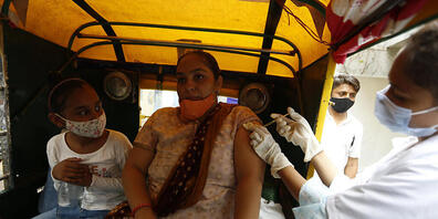 Eine Mitarbeiterin des Gesundheitswesens impft in Ahmedabad eine Frau gegen das Coronavirus. Foto: Ajit Solanki/AP/dpa