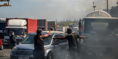 Demonstranten verhindern die Durchfahrt von Autos indem sie eine Hauptstraße mit brennenden Reifen blockieren. Die Demonstranten protestieren gegen die kollabierende Wirtschaft und den Lebensstandard im Libanon. Foto: Marwan Naamani/dpa