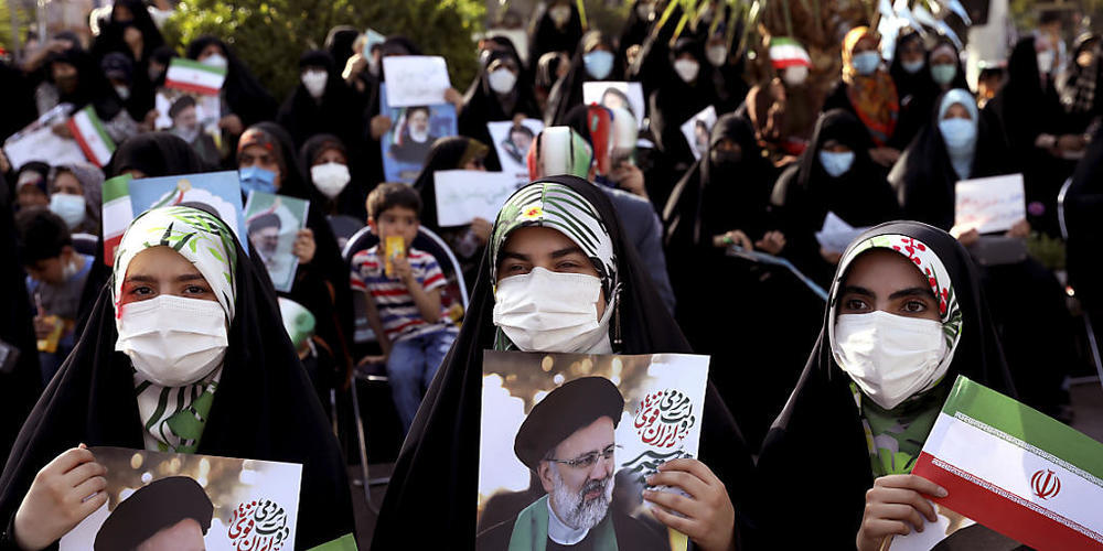 Unterstützerinnen des Präsidentschaftskandidaten Ebrahim Raisi halten während einer Demonstration für ihn Fotos von ihm. Foto: Ebrahim Noroozi/AP/dpa