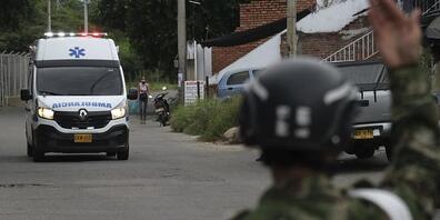 Ein Soldat gibt einem Krankenwagen Signale. Bei einem Anschlag auf einen Militärstützpunkt im Osten Kolumbiens sind dutzende Menschen verletzt worden. Foto: Ferley Ospina/AP/dpa