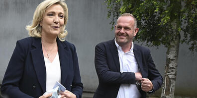 Marine Le Pen, Parteivorsitzende der Rassemblement National,  und der lokale Kandidat Steeve Briois gehen nach der Stimmabgabe bei den Regionalwahlen. Foto: Uncredited/AP/dpa