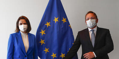Swetlana Tichanowskaja, Oppositionsführerin aus Belarus, und Oliver Varhelyi, Erweiterungskommissar der EU, stehen zusammen vor einer Fahne der EU während eines Treffens der Außenminister der EU im Gebäude des Europäischen Rates. Foto: Johanna Ger...