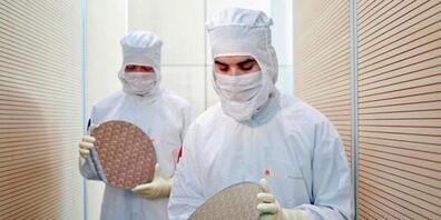 Die Chipbrance investiert derzeit massiv in neue Fabriken - im Bild Dresdner Globalfoundries-Arbeiter mit Chip-Wafern. (Archivbild)