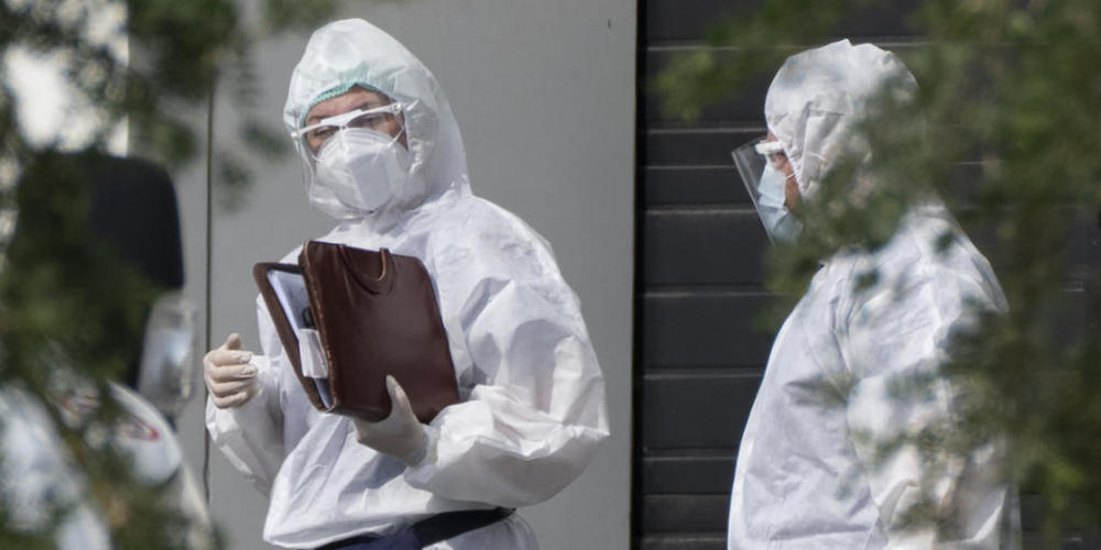Medizinische Mitarbeiter in Schutzkleidung unterhalten sich, während sie einen Patienten mit Verdacht auf eine Coronavirus-Erkrankung in einem Krankenhaus transportieren. Die russische Hauptstadt Moskau verzeichnet weiterhin Tausende Corona-Neuinf...