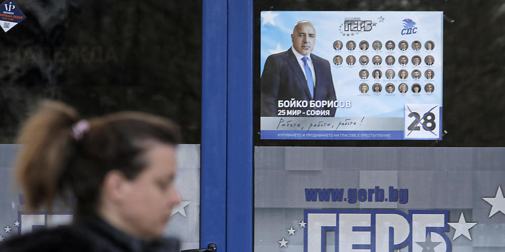 ARCHIV - Eine Frau geht an einem Plakat in Sofia vorbei, das den bulgarischen Premierminister Borissow zeigt. Foto: Valentina Petrova/AP/dpa