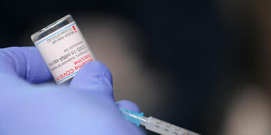 Ein Arzt zieht eine Spritze mit dem Impfstoff von Moderna auf. Foto: Oliver Berg/dpa