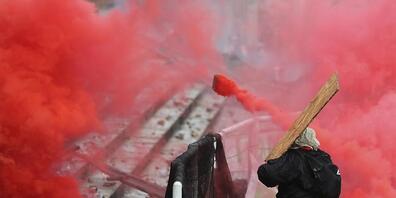 Ein regierungskritischer Demonstrant wirft einen Tränengaskanister zurück. Foto: Fernando Vergara/AP/dpa