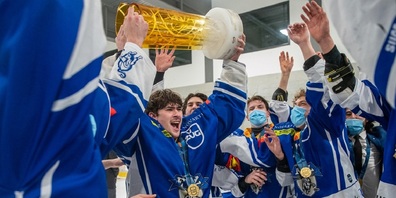 Jan Rutz hebt den Pokal nach dem Gewinn der U20 Elit-Schweizermeisterschaft 2020/21.