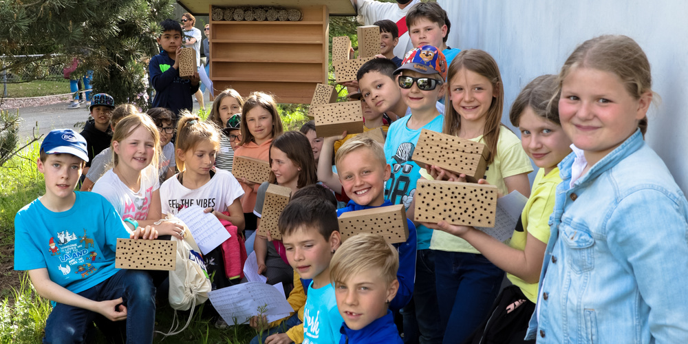 Die Diepoldsauer Erstkommunion-Kinder mit Diakon Bernd bei der Einweihung des neuen Wildbienenhotels.