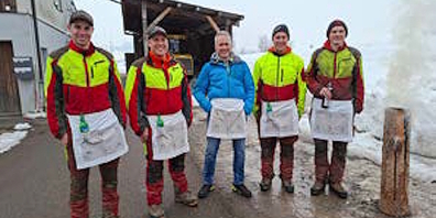 Reto Bless (3.v.l.) und das Forst-Team des Forstbetriebs Kaltbrunn bei seiner Verabschiedung mit einem Fondue über dem offenen Feuer.
