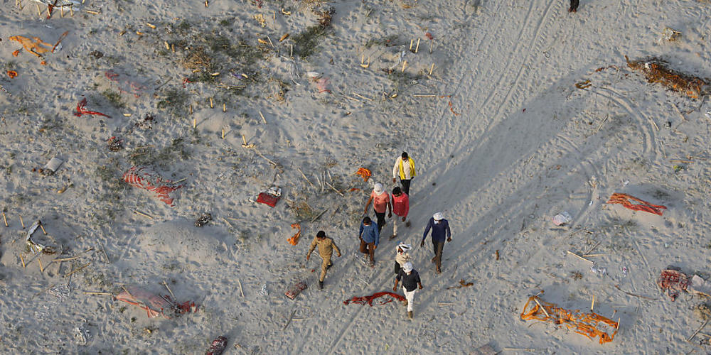 Leichen von mutmaßlichen Opfern des Coronavirus liegen in flachen Gräbern in einem Krematorium am Ufer des Ganges. Foto: Rajesh Kumar Singh/AP/dpa