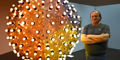 Erich Wessner, dienstältester Mitarbeiter im Vögele Kultur Zentrum, mit dem Werk Leuchtkugel von Francesco Mariotti.