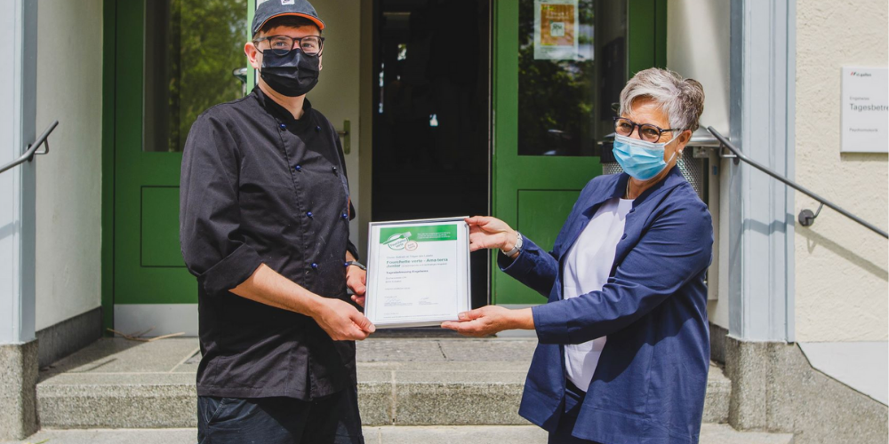 Claudia Rey, Ernährungsberaterin der Stadt St.Gallen, übergibt Laurin Keller, Koch der Tagesbetreuung Engelwies, die Zertifizierung.