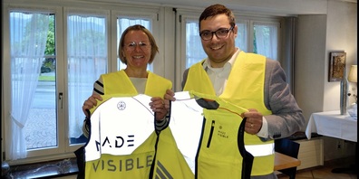 Evelyn Tremp, Leiterin Kita Benken, freut sich bei der Übergabe durch Vito Leo, TCS Präsident See-Gaster,über die neuen Leuchtwesten.