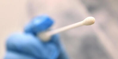 ARCHIV - Ein Arzt hält einen Tupfer mit dem ein Abstrich für einen Coronatest gemacht wird. Foto: Karl-Josef Hildenbrand/dpa