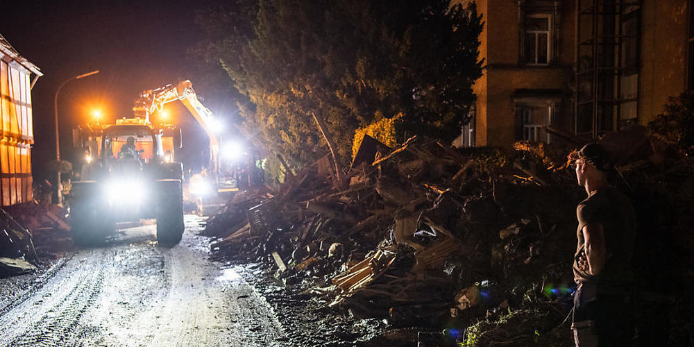 Trümmerteile werden von einem Bagger mit Anhänger im Landkreis Ahrweiler in Rheinland-Pfalz verladen. Nach der Hochwasserkatastrophe im Westen Deutschlands ist die Zahl der Toten auf mehr als 130 gestiegen. Foto: Lino Mirgeler/dpa