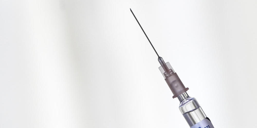 ARCHIV - Ein Arzt hält eine Spritze mit einer Grippeimpfung der Influenza-Saison 2020 / 2021 in der Hand. Foto: Jens Kalaene/dpa-Zentralbild/dpa