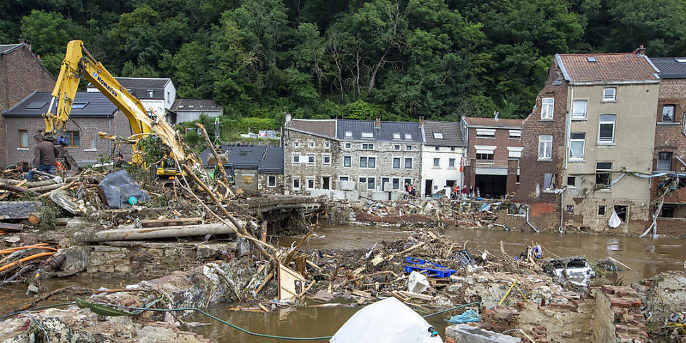 Anwohner im Ort Pepinster beseitigen Trümmer mit einem Bagger. Foto: Nicolas Maeterlinck/BELGA/dpa