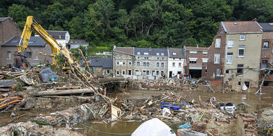 Anwohner im Ort Pepinster beseitigen Trümmer mit einem Bagger. Foto: Nicolas Maeterlinck/BELGA/dpa