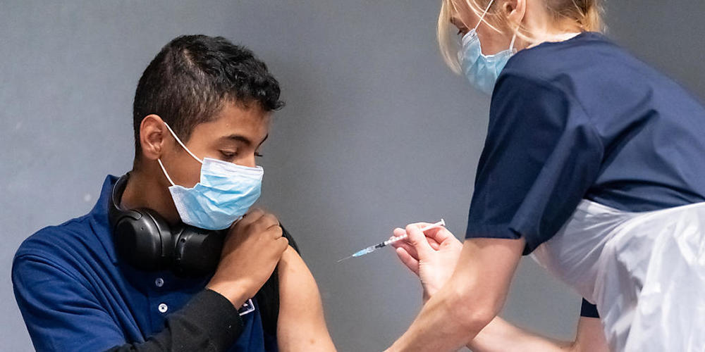 Die Krankenschwester Sonia Wilson (r) impft den 18-jährigen Cameron Ladd mit dem Corona-Impfstoff von Biontech/Pfizer in einem Massenimpfzentrum in Doncaster. Foto: Danny Lawson/PA Wire/dpa