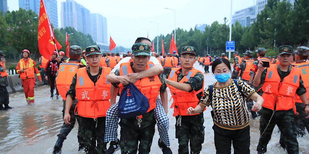 Mitarbeiter des Militärs tragen Patienten eines Krankenhauses über eine überschwemmte Straße. Laut Angaben des chinesische Staatsfernsehens am Freitag ist die Zahl der Toten nach den schweren Überschwemmungen in der chinesischen Metropole Zhengzho...