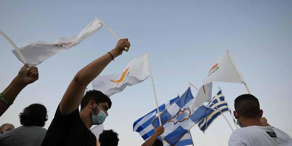 Bewohner der verlassenen Stadt Varosha oder Famagusta halten zypriotische und griechische Fahnen während eines Protestes gegen die türkische Regierung. Die Europäische Union droht der Türkei wegen der jüngsten Eskalation des Zypernkonflikts mit Sa...