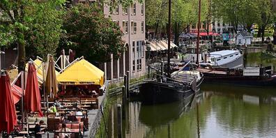 ARCHIV - Nur wenige Gäste sitzen bei sonnigem Wetter in den Außenbereichen der Cafés und Restaurants am Historischen Hafen in Rotterdam Foto: Soeren Stache/dpa-Zentralbild/dpa