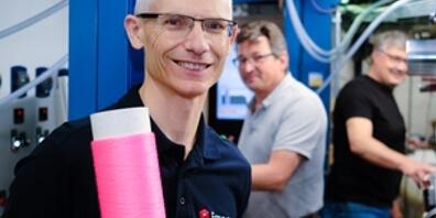 Rudolf Hufenus vor der Maschine, die als Weltneuheit Übertragungskabel mit Flüssigkern herstellt. Die Spule, die er in der Hand hält, ist nicht nur rosa, damit sie schick aussieht: Die Farbe erlaubt, die Dehnung der Faser zu messen. Das erweitert ...