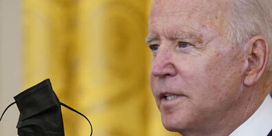Joe Biden, Präsident der USA, hält seinen Mund-Nasen-Schutz während er im East Room des Weißen Hauses in Washington über die Impfvorschriften für Bundesbedienstete spricht. Foto: Susan Walsh/AP/dpa