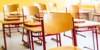 Stühle stehen auf den Tischen in einem leeren Klassenzimmer. Foto: Philipp von Ditfurth/dpa