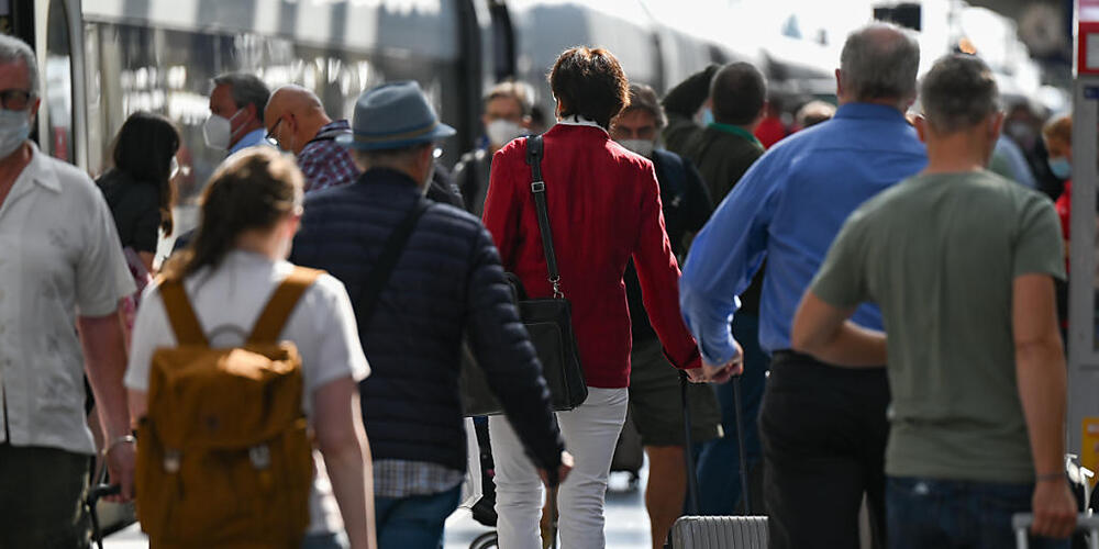 ARCHIV - Bahnreisende gehen auf einem Gleis im Frankfurter Hauptbahnhof an einem ICE der Bahn vorbei. Foto: Arne Dedert/dpa