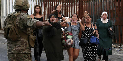 Ein Soldat weist nach Schüssen in der Küstenstadt Khaldeh einer Gruppe Frauen den Weg während der Evakuierung. Foto: Bilal Hussein/AP/dpa