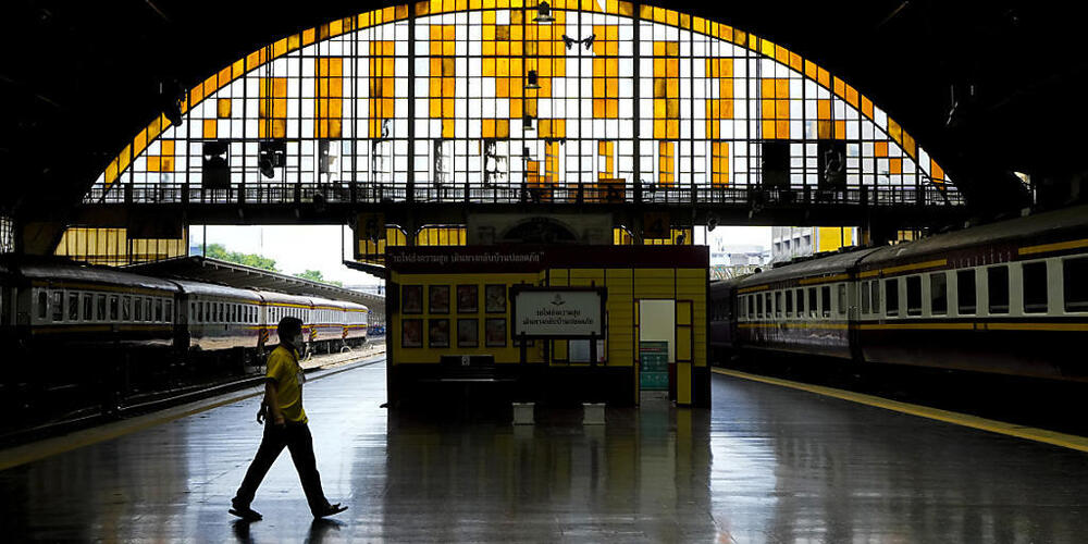 Ein Mann mit Mund-Nasen-Schutz geht über den ansonsten menschenleeren Bahnsteig der 104 Jahre alten Hua Lamphong Railway Station. Foto: Sakchai Lalit/AP/dpa
