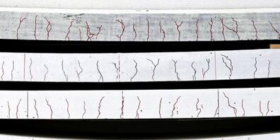 Ramponierte Betonplatten in verschiedenen Stärken. Von unten nach oben: unbehandelt, mit kohlefaserverstärktem Kunststoff versehen, zusätzlich gerillt, gerillt und vorgespannt (Pressebild).