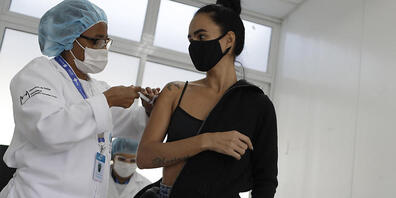 Eine Mitarbeiterin des Gesundheitswesens verabreicht in der Favela Complexo da Mare in Rio de Janeiro eine Dosis des Corona-Impfstoffs von Astrazeneca. Foto: Bruna Prado/AP/dpa