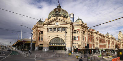 A lone person crosses a quiet Flinders Street in Melbourne, Wednesday, August 11, 2021. Regional Victoria's lockdown is over but people in Melbourne are still days from finding out when theirs will end.  (AAP Image/Daniel Pockett) NO ARCHIVING