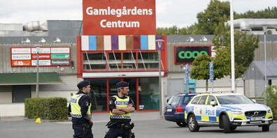 ARCHIV - Zwei Polizisten stehen am Tatort nach mutmaßlichen Schüssen im Stadtteil Nasby auf einem Parkplatz. Das EU-Land Schweden hat ein Problem: eine eskalierende Bandenkriminalität. Wird Schweden somit zum Gangster-Paradies - oder ist es das sc...