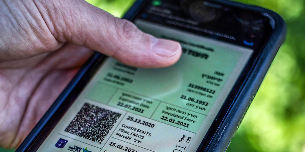 ARCHIV - Ein israelischer Mann hält ein Smartphone in der Hand, auf dem der sogenannte "Grüne Pass" abgebildet ist. Angesichts stark ansteigender Corona-Infektionszahlen dehnt Israel die Anwendung des sogenannten Grünen Passes auf fast alle Bereic...