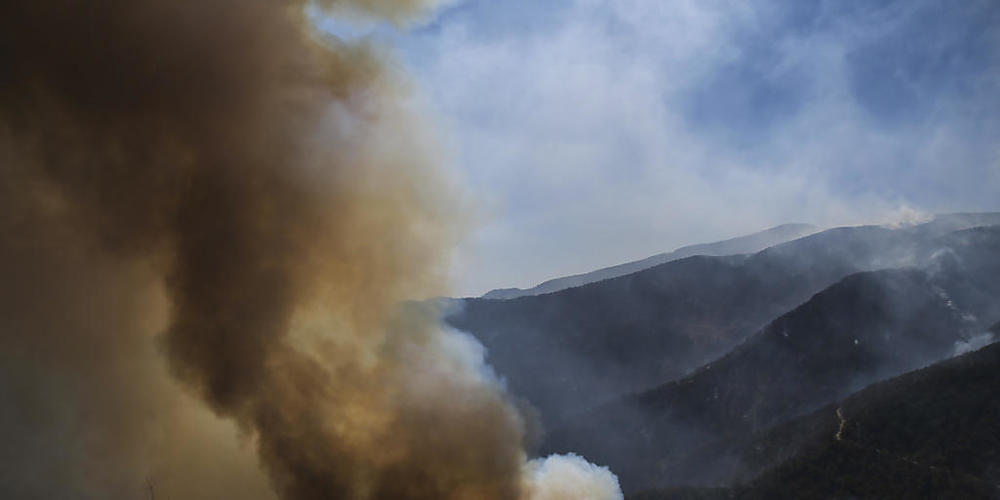 Rauch und Flammen steigen empor während eines Waldbrandes in Koycegiz. Seit dem 28. Juli kämpfen Einsatzkräfte gegen die massiven Waldbrände inmitten einer heftigen Hitzewelle. Foto: Emre Tazegul/AP/dpa