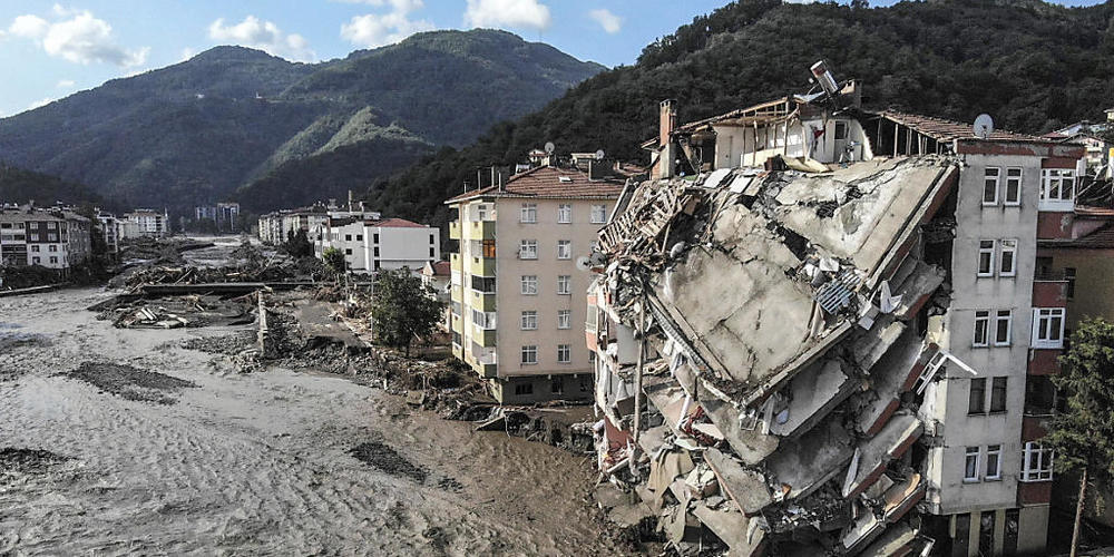 Ein Luftbild zeigt zerstörte Gebäude nach Überschwemmungen und Schlammlawinen. Foto: Ismail Coskun/IHA/AP/dpa