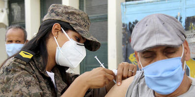 Eine Soldatin verabreicht einem Mann in der Assad-Iben-El-Fourat-Schule den Corona-Impfstoff Vaxzevria während einer Impfaktion. Um die katastrophale Corona-Lage in Tunesien in den Griff zu bekommen, hat eine Impfaktion für bis zu eine Million Bür...