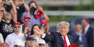 Der ehemalige US Präsident Donald Trump wirft «Save America»-Hüte, bevor er bei einer Kundgebung auf dem Lorain County Fairgrounds spricht. Foto: Tony Dejak/AP/dpa