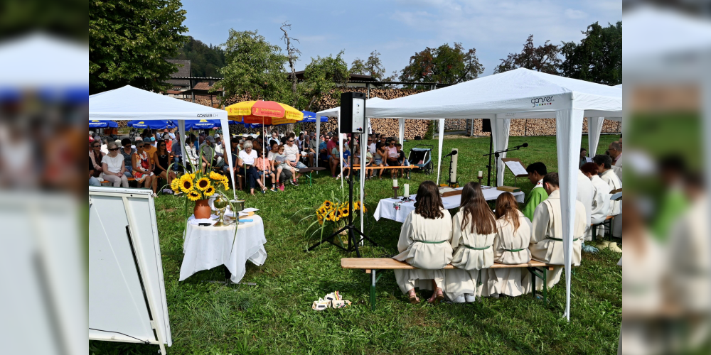 Über 100 Personen nehmen bei sonnigem Wetter am Gottesdienst teil.